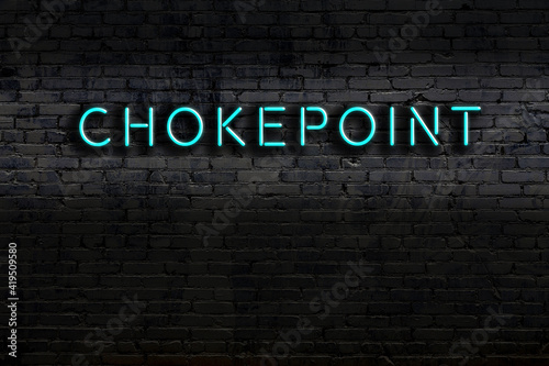 Neon sign. Word chokepoint against brick wall. Night view photo