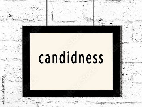 Принти на полотні Black frame hanging on white brick wall with inscription candidness