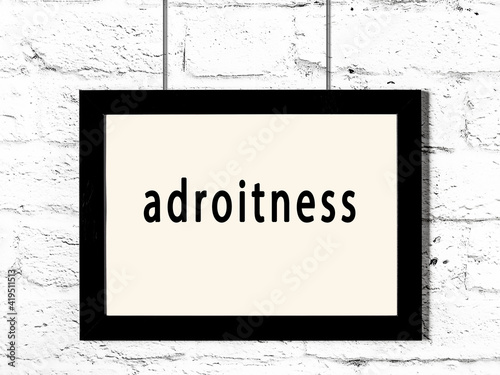 Black frame hanging on white brick wall with inscription adroitness