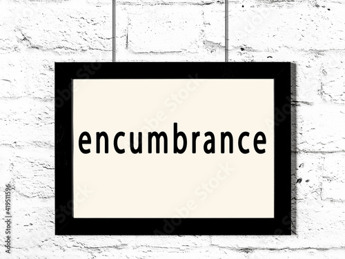 Black frame hanging on white brick wall with inscription encumbrance