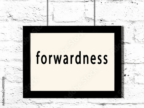 Black frame hanging on white brick wall with inscription forwardness photo