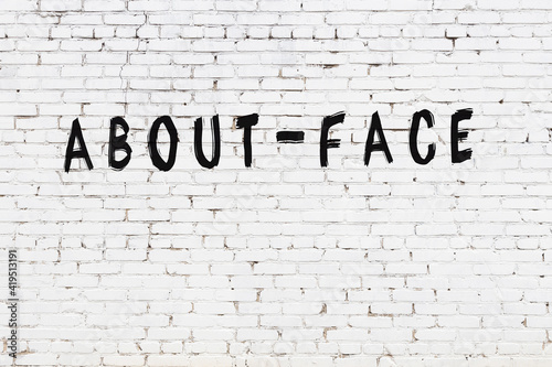 Inscription about-face painted on white brick wall