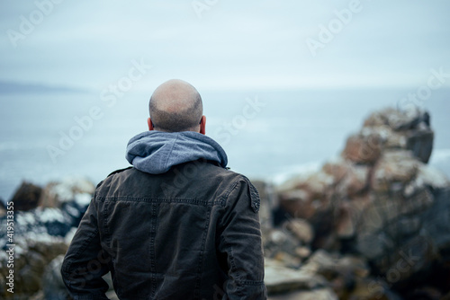 Back portrait of man watching the sea