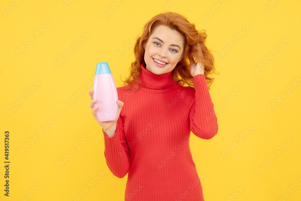 Beautiful woman with organic shampoo over light yellow background, Beautiful woman with organic shampoo over light yellow background,