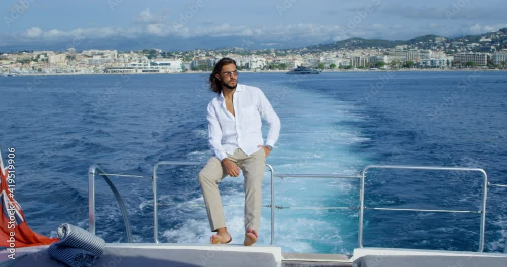 Man with sunglasses stands on a boat and looks at the horizon with an island in the background - RED Camera 4K Man with sunglasses stands on a boat and looks at the horizon with an island in the background - RED Camera 4K