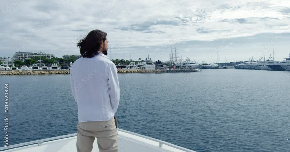 Handsome man from behind with brown hair standing on a boat sailing into the seagate - Cinematic scene with RED Camera 4K Handsome man from behind with brown hair standing on a boat sailing into the seagate - Cinematic scene with RED Camera 4K