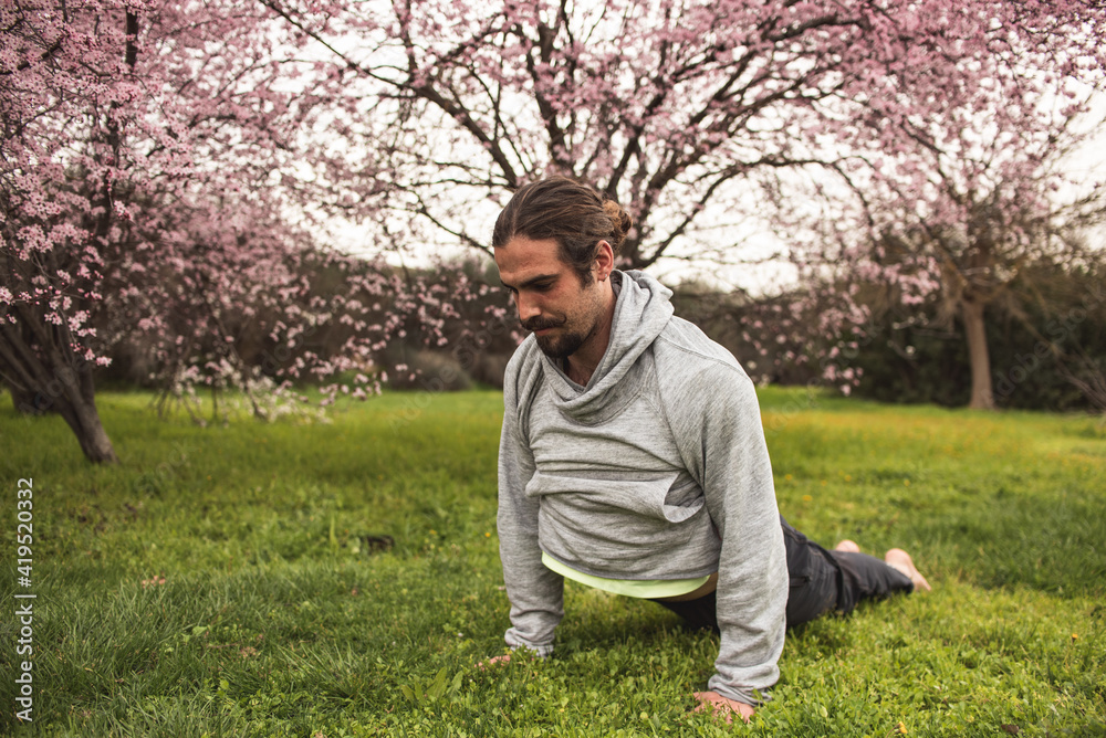 Young man stretching for a yoga session in the park. Fitness, healthy habits and wellness concepts. Young man stretching for a yoga session in the park. Fitness, healthy habits and wellness concepts.