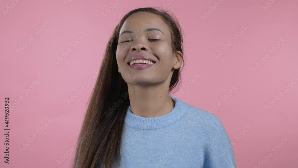 African woman showing thumb up sign on pink background. Positive young girl smiles to camera. Winner. Success. Body language. African woman showing thumb up sign on pink background. Positive young girl smiles to camera. Winner. Success. Body language.