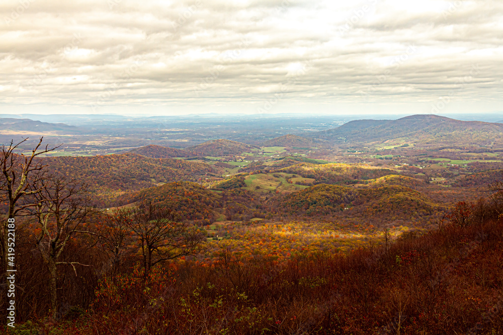  Shenandoah Valley as observed from a scenic outlook by the Skyline drive. Blue ridge mountains are seen as silhouettes on western horizon. Colors of autumn dominate the picture