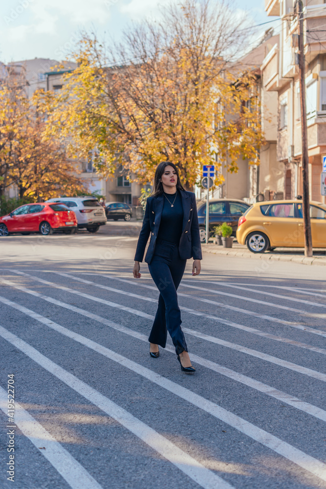 Formally dressed businesswoman in high heels passing the streets in an urban city
