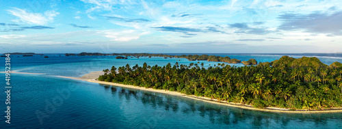 A panorama of a beautiful palm lined beach ion Lau group Fiji shot from a drone.