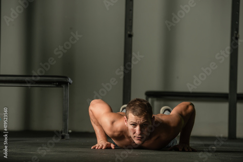 Strong male athlete doing push-ups indoors. Close up perspective, healthy lifestyle, fatless body.