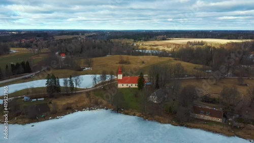 Araisi Lake Castle in Latvia Aerial Shot From Above. Historical Wooden Buildings on Small Island in the Frozen Lake Araisi in the Winter and the Ruins of the Old Medieval Castle photo