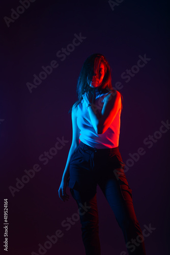 Blue and red light portrait of a female model on a black background with high contrast