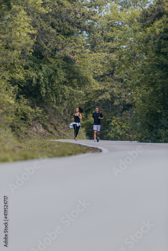 Athletic couple running on a street next to each other. Nature,fit and healthy concept. © qunica.com
