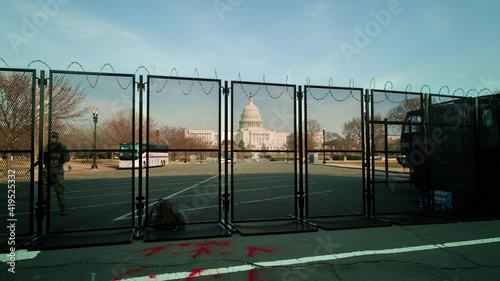 A time-lapse of the security perimeter, manned by National Guard troops, in front of the U.S. Capitol building at sunset. The fence was erected following the January 6 riot. The camera tracks left.
