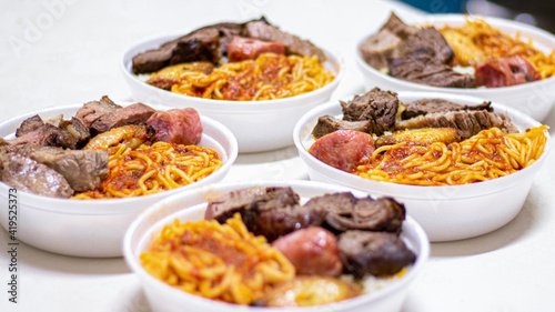 Marmitex with meat, pasta and rice in a white bowl - packed lunch - Brazilian Food.