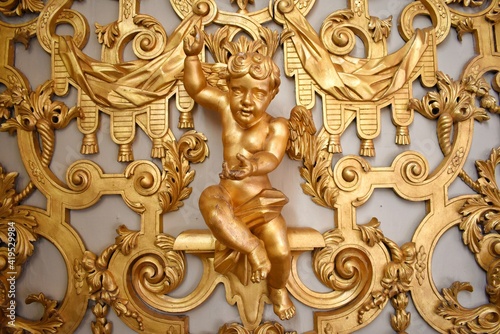 Golden Cupid's statue and the golden background in Storkyrkan church.