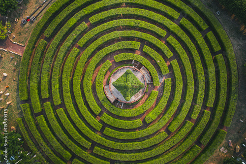 Aerial view of a circular garden maze and green pavilion