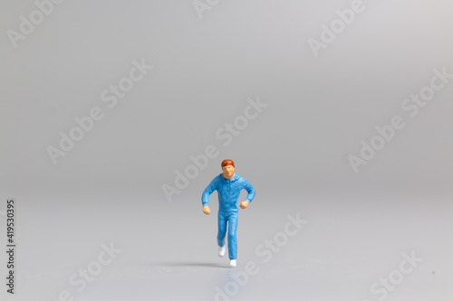 Miniature people Running on gray background and free space for text , Run for health concept