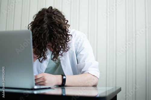 Copy space. mental health. Caucasian man with curly hair bowed his head due to work fatigue.