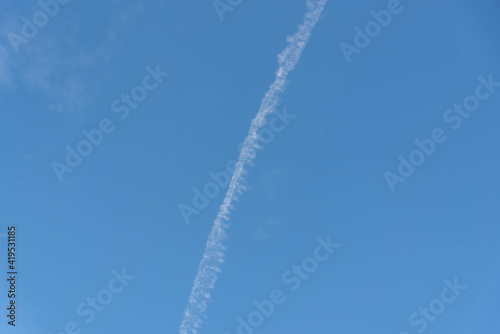 Blue sky cut by smoke from airplane fuel © Alex R. Brondani