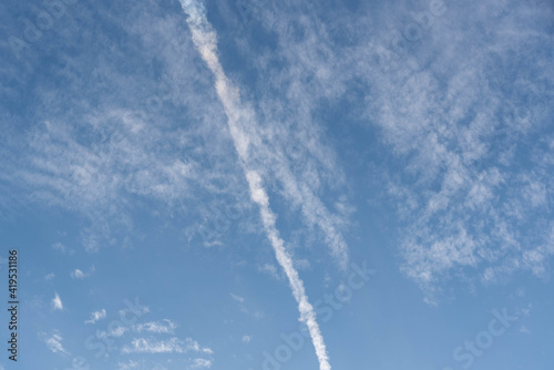 Blue sky cut by smoke from airplane fuel