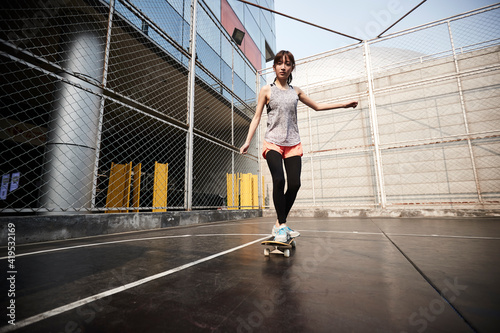 young asian skateboarder skateboarding outdoors