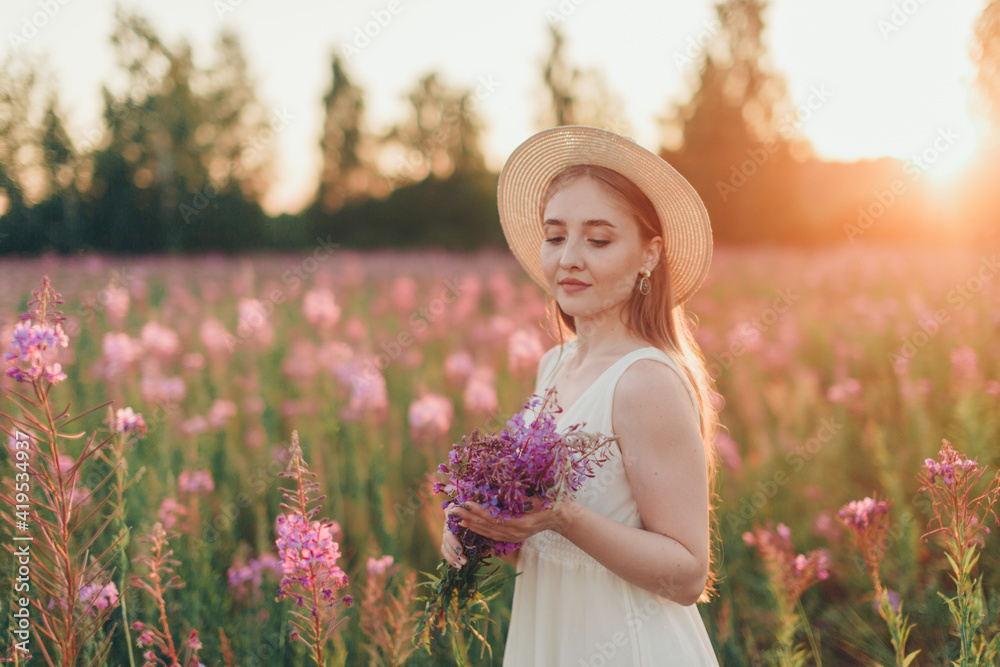 Fototapeta premium a happy girl with bouquet walks through a flower meadow. Love and spring blooming