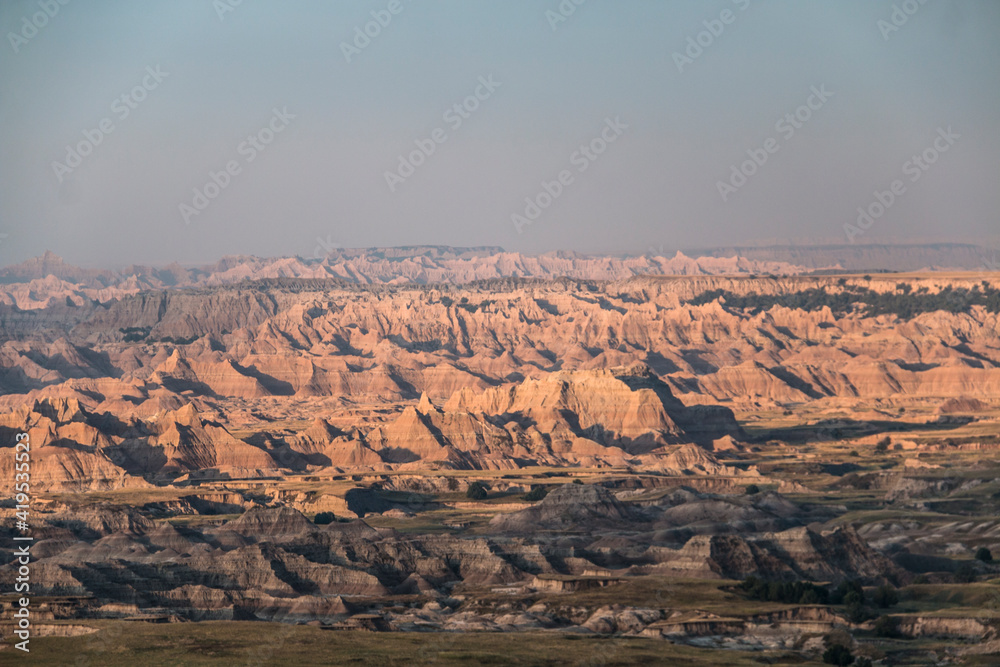 dramatic rock formations and open grasslands in Badlands national park in South Dakota.