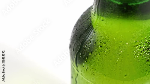 close up. drops flow down the cold green glass of the bottle. condensate