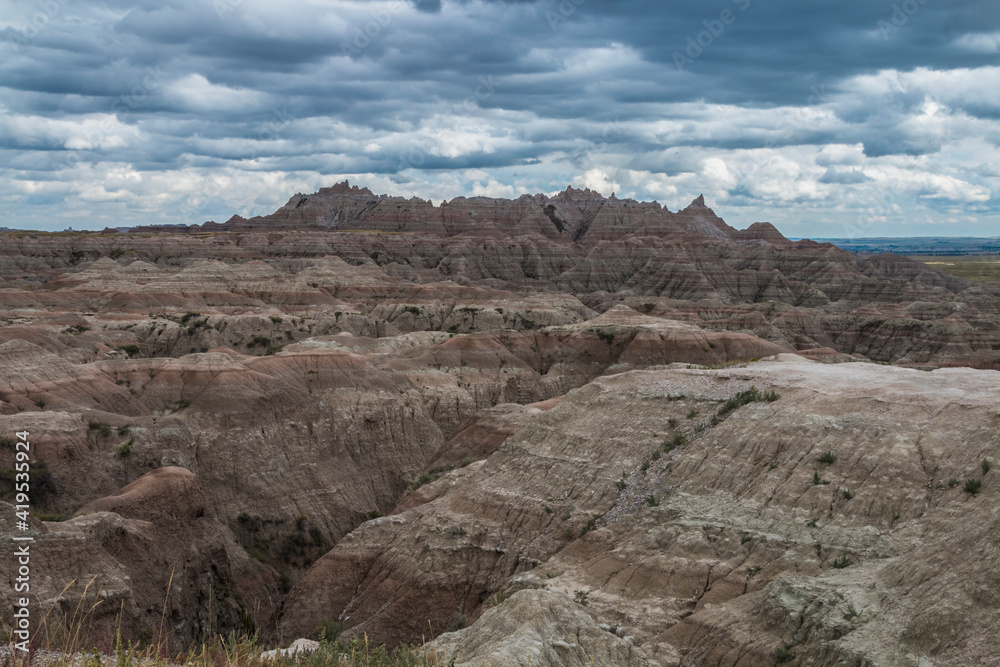 low cotton like summer clouds covering the sky in Badlands National Park in South Dakota.