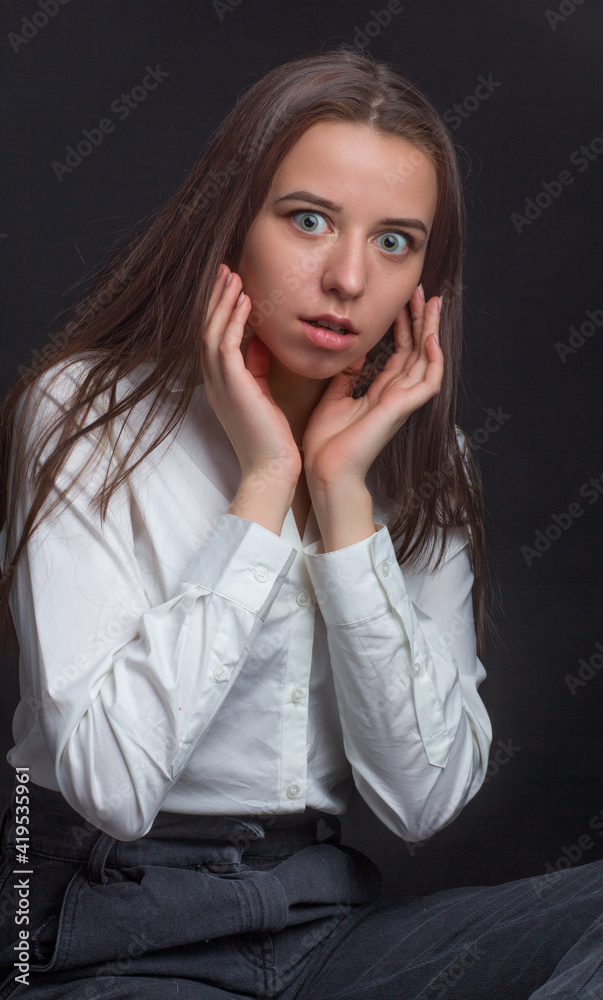 brown-haired girl with long hair, in a white shirt, on a black background brown-haired girl with long hair, in a white shirt, on a black background