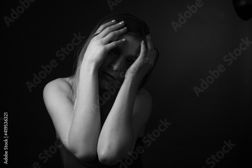 black and white portrait of an adult woman in a studio on a black background.