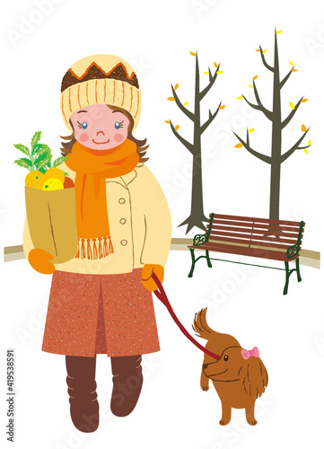 A woman is walking in the park with her dog