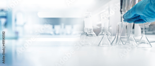 hand of scientist with test tube and flask in medical chemistry lab banner background.