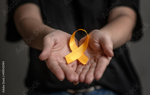 Hands hold yellow ribbon. Concept of suicide problems and their prevention photo