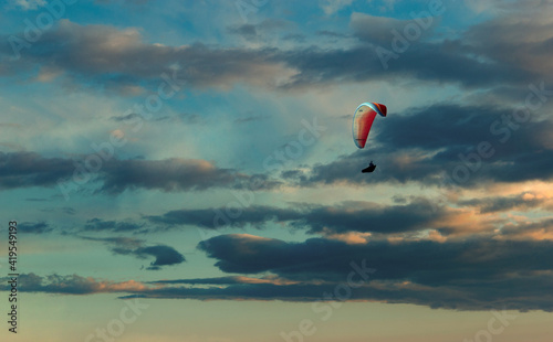 Paraglider flying in the beautiful sky against the background of clouds.
