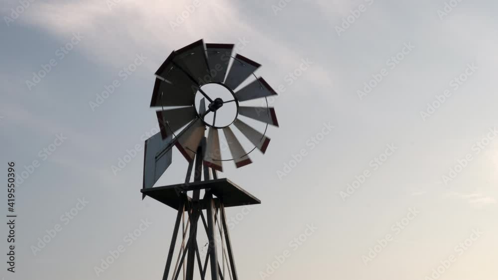 A small windmill turning in the light of the evening sun and breeze. A small windmill turning in the light of the evening sun and breeze.