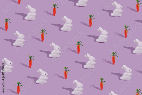 Pattern with white rabbit and orange carrot on violet background.