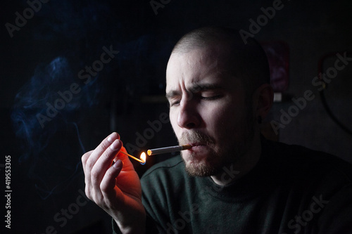 Young man with cigarette in hand feeling lonely and depressed