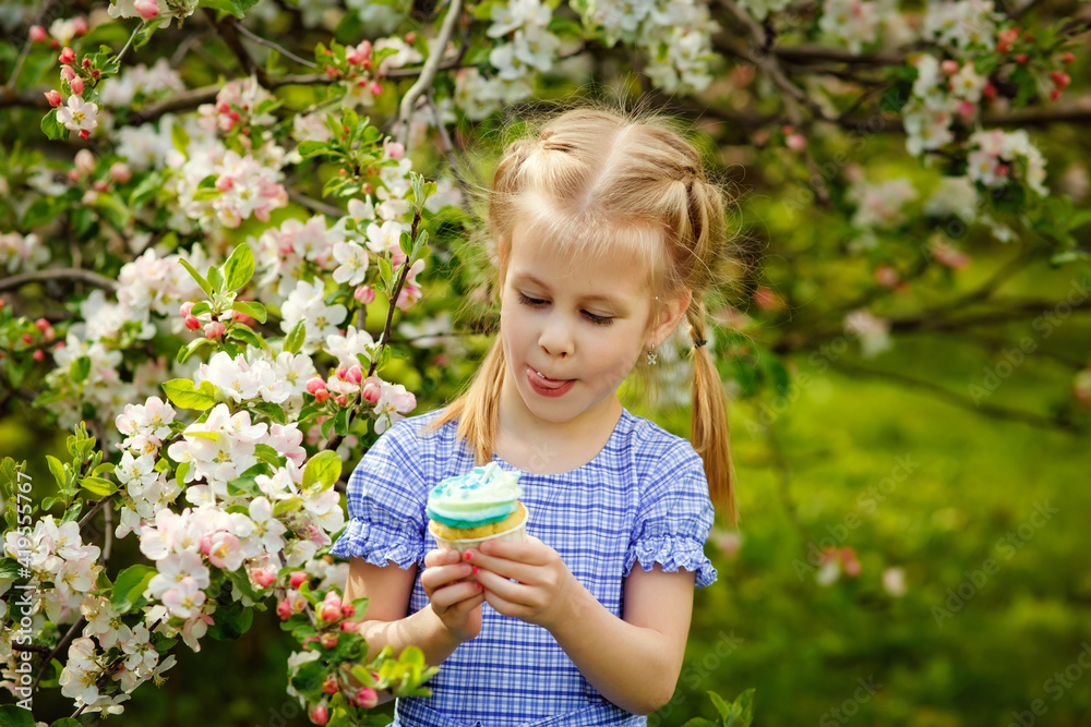 A child in a blooming apple orchard enjoys a warm spring day. The girl holds a cake in her hands, wants to eat it. A child in a blooming apple orchard enjoys a warm spring day. The girl holds a cake in her hands, wants to eat it.