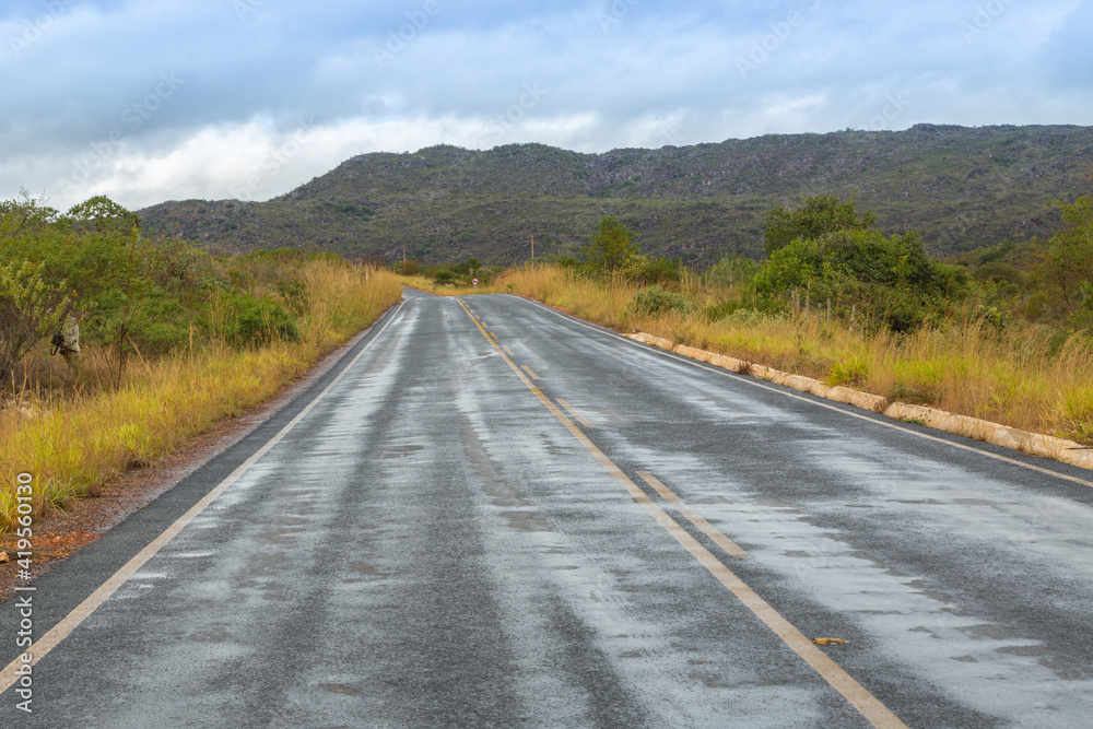 Wet straight tarred road after rain on a cloudy day close to Grao Mogol in Minas Gerais, Brazil