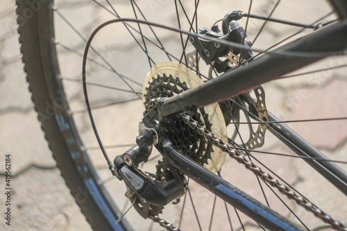 closeup view of a used and dirty road bicycle cassette and brakes on a rear wheel