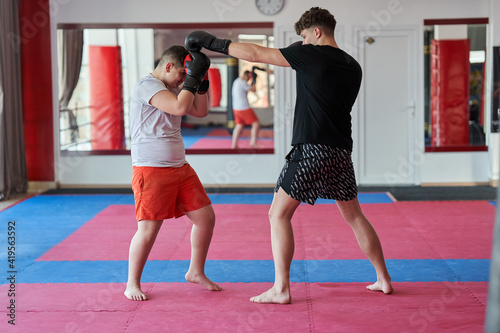 Overweight kickboxer sparring with his partner