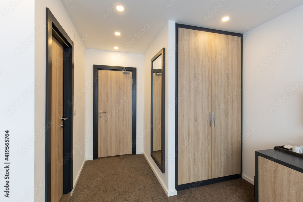 Hotel room entrance corridor with wooden closet