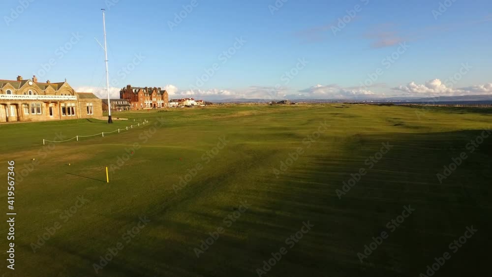 Aerial Forward: Buildings At Golf Course Against Blue Sky