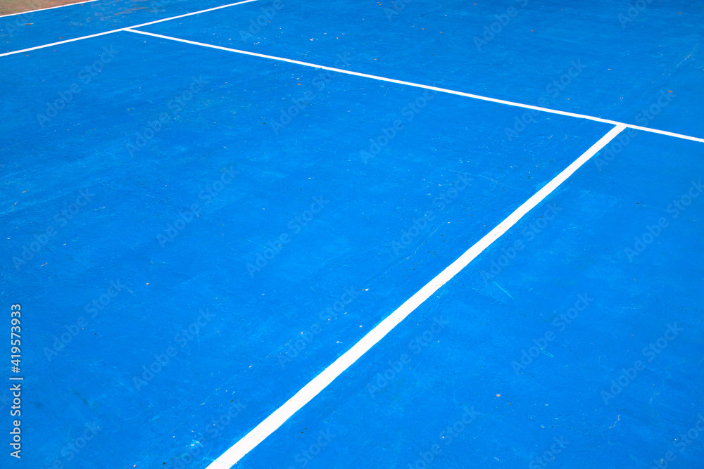 Blue tennis court with white mark. Empty sport field photo. Hard cover surface for lawn tennis. Summer sport activity outdoor. White markup on blue court. Sunny day on tennis court. Sport abstraction