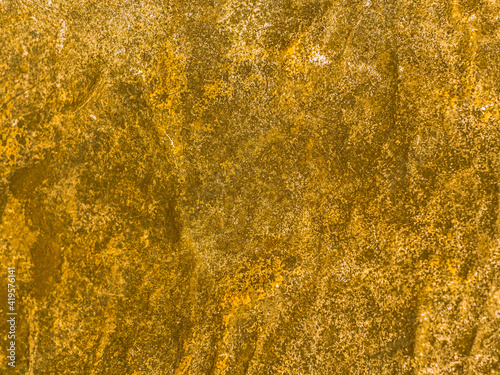 Gold texture rough leaf foil background. Shiny yellow abstract textured golden stone