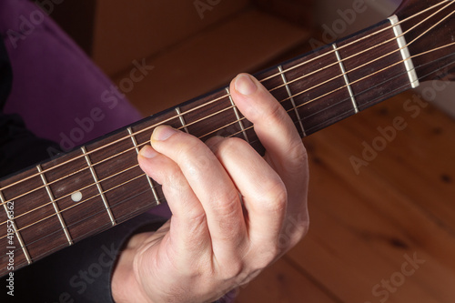 Close-up on the hand of a man playing guitar